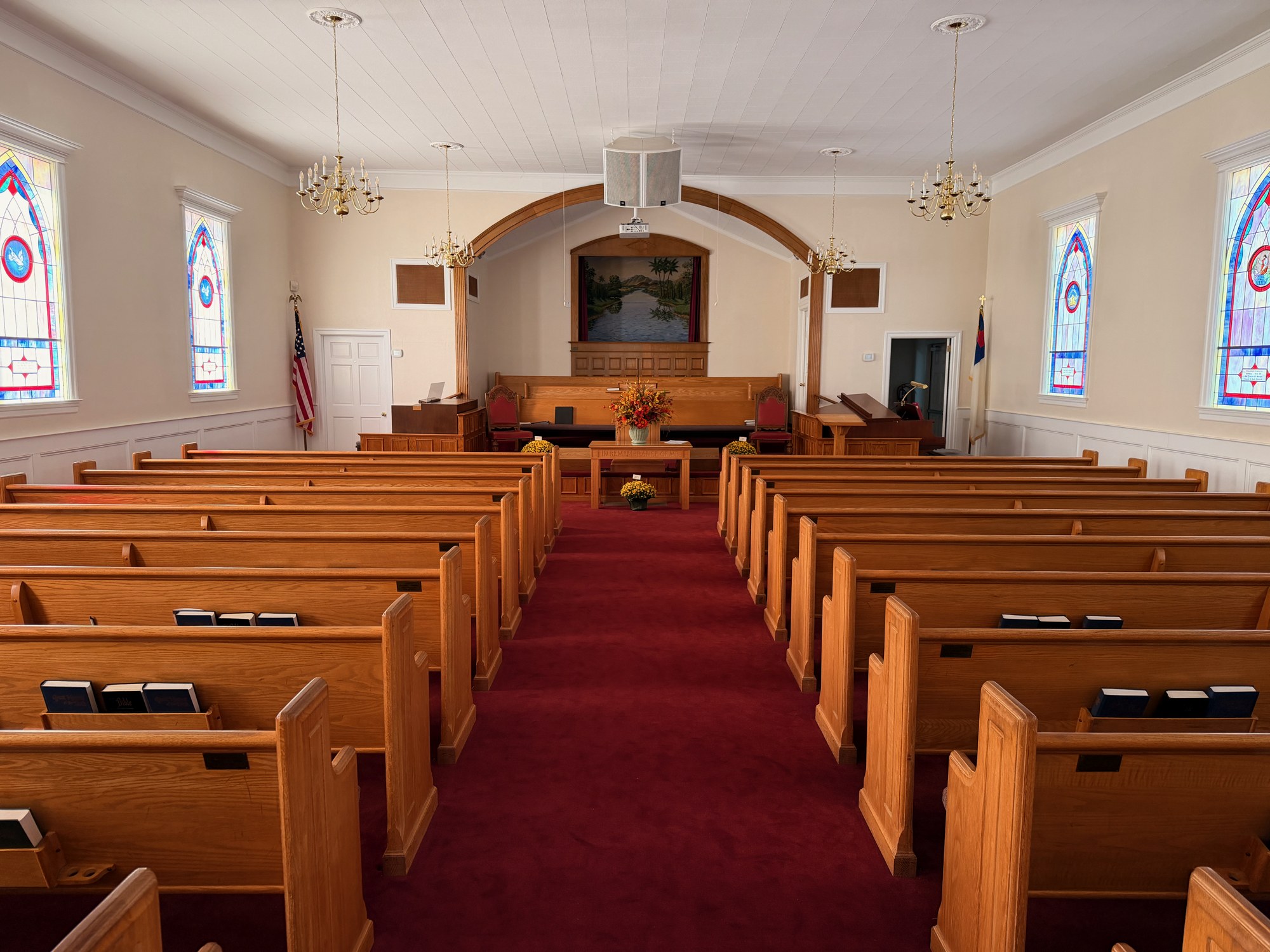 Wooden pews and stained-glass windows inside the Antioch sanctuary